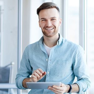 Ein Mann im Büro hält ein Tablet