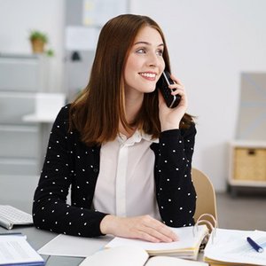 Eine Bueromanagerin die telefoniert